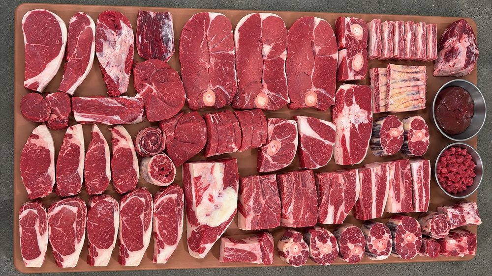 A quarter beef share laid out on the board: ribeyes, strips, ribs, roasts and ground beef, seen from above